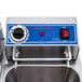 A Globe dual tank electric countertop fryer on a metal surface with a red switch and blue buttons.