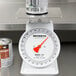 A Cardinal Detecto T25 mechanical portion scale on a counter next to a can of paint.