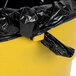 A black plastic bag in a yellow Continental 32 gallon round trash can.