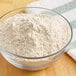 A bowl of ADM Extra Fine White Whole Wheat Flour on a table.