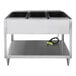 A stainless steel electric three-pan hot food table with a lower shelf and power cord.