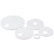 A close up of three white plastic caps with holes.