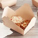 A Fold-Pak Bio-Plus-Earth paper take-out box filled with rice and vegetables.