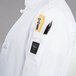 a person wearing a white coat with a pocket full of items