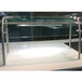 An Advance Tabco stainless steel food shield with glass shelves over a counter.