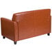 A Flash Furniture brown leather loveseat with wooden legs.