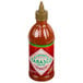 A 20 oz. red bottle of TABASCO Sriracha Hot Sauce with a label.