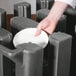 A person's hand using a Cambro granite gray dish dolly to hold a white plate.