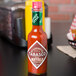 A bottle of TABASCO Buffalo Style hot sauce on a table.