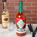 A bottle of TABASCO Original Bloody Mary Mix on a table with shot glasses.