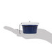 A hand holding a blue fluted CAC China ramekin.