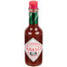 A close-up of a TABASCO® 5 oz. bottle of Sweet & Spicy Hot Sauce with a green label.