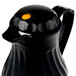 A black pitcher with a yellow dot on top.