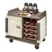 A Cambro meal delivery cart with trays of food on it.