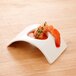 A shrimp in an Arcoroc rectangular porcelain bowl with sauce.