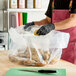 A large clear plastic food bag filled with potatoes on a kitchen counter.