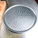 An American Metalcraft heavy weight aluminum pizza pan with perforations.