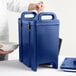 A man holding a blue Cambro insulated soup carrier with a white bowl.