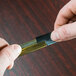 A close-up of a person's hand holding an Unger Soft Rubber Squeegee Blade.