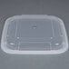 A Pactiv Newspring VERSAtainer black plastic container with a clear plastic lid.