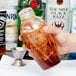 A person using a Fineline clear plastic shaker filled with ice.