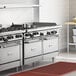 A commercial stainless steel 60-inch range with four burners, a 36-inch griddle, and two standard ovens.