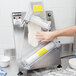 A man using a Doyon countertop dough sheeter to roll dough.