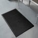 a black rubber mat on a white floor