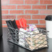 An American Metalcraft chrome birdnest coffee caddy on a metal rack with straws and condiments.