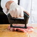 a person using a meat cutter