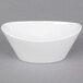 A CAC Super White Oval Porcelain Monkey Dish on a gray surface.