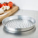 An American Metalcraft silver aluminum pizza pan with holes.