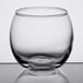 A close-up of a clear Libbey glass votive candle holder.