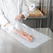 A chef using an ARY VacMaster vacuum packaging bag to put meat in.