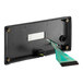 A black rectangular device with a green ribbon.