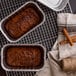 Two D&W foil bread loaves on a counter in tins.
