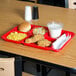 A red Carlisle 6 compartment tray with food on it.