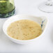 A bowl of soup in a Thunder Group Blue Bamboo melamine bowl on a table.