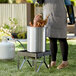 A woman using a Backyard Pro turkey fryer kit to cook a turkey.