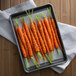 Sliced carrots with Regal Honey Sweet Herb Blend on a baking sheet.