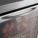 A Turbo Air undercounter refrigerator with a glass door filled with fruit including apples, pineapples, and grapes.