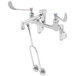A chrome T&S wall mount mop sink faucet with wrist handles and a hose outlet.