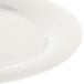 A close-up of a Carlisle white melamine plate with a wide rim.