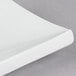 A close up of a CAC rectangular bone white porcelain platter with curved edges.