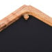 A Tablecraft rectangular acacia wood underliner with a black chalkboard silicone liner.