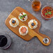 A Tablecraft acacia wood bread board with food on it.