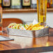 A silver Tablecraft rectangular metal platter with tacos and chips on a table.