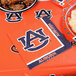 A package of 240 Auburn University 2-ply luncheon napkins on a table with food.