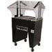 An Advance Tabco stainless steel hot food table with an open base and clear glass sneeze guard.