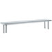 An Advance Tabco stainless steel shelving unit with a long shelf mounted on a table.